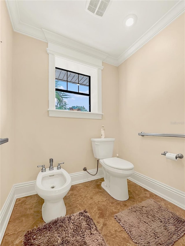 bathroom featuring tile patterned flooring, toilet, ornamental molding, and a bidet