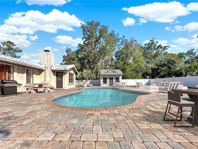 view of pool with area for grilling, a patio area, and an outbuilding