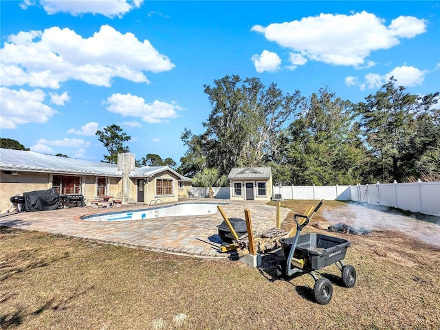 view of pool featuring an outbuilding, a yard, and a patio