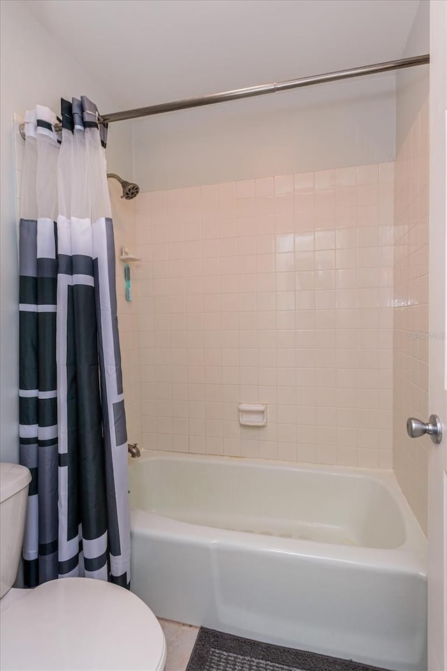 bathroom with shower / tub combo with curtain and toilet