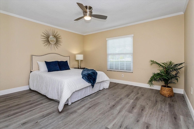 bedroom featuring hardwood / wood-style flooring, ceiling fan, crown molding, and a textured ceiling