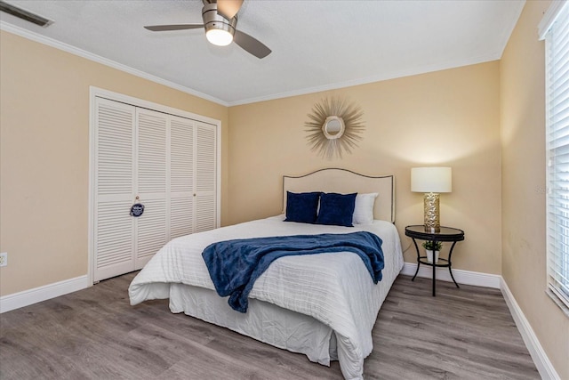 bedroom featuring ceiling fan, a closet, ornamental molding, and hardwood / wood-style flooring