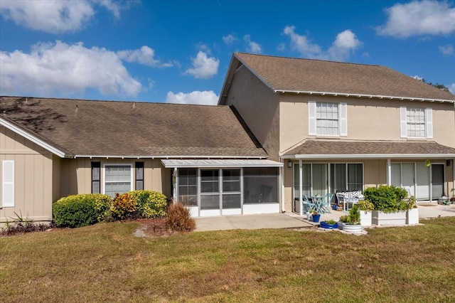 rear view of house featuring a sunroom and a lawn