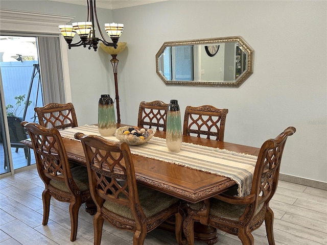 dining room with ornamental molding, light hardwood / wood-style floors, and a notable chandelier