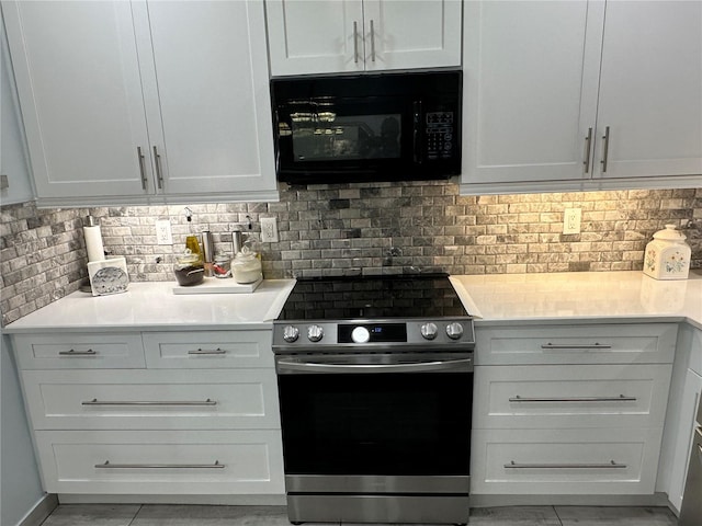 kitchen featuring stainless steel range and white cabinets