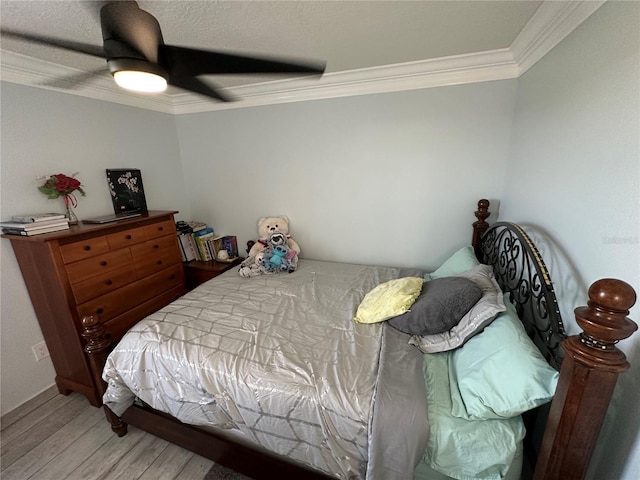 bedroom with ceiling fan, crown molding, and hardwood / wood-style flooring