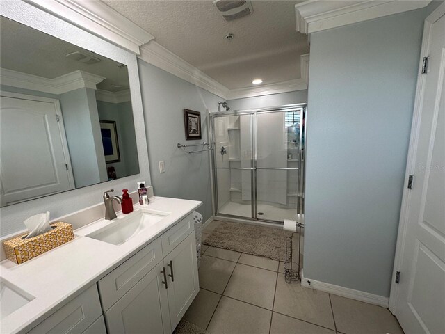 bathroom with tile patterned flooring, vanity, a shower with shower door, and ornamental molding