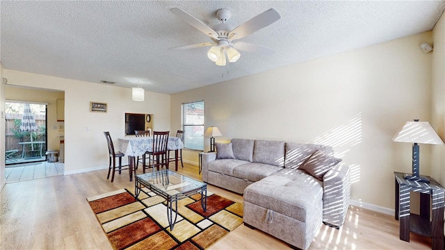 living room with light hardwood / wood-style floors, plenty of natural light, and ceiling fan