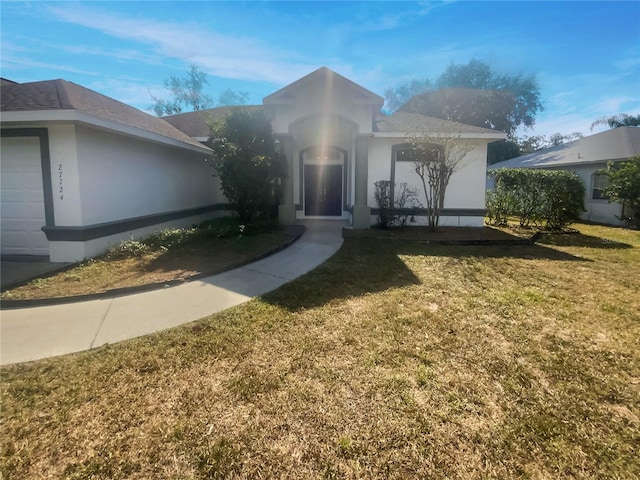 view of front of home with a front lawn and a garage