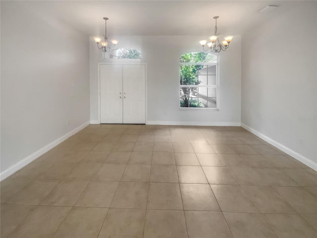 unfurnished room featuring light tile patterned flooring and an inviting chandelier