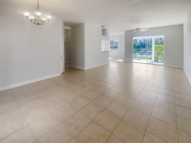 spare room with light tile patterned floors and ceiling fan with notable chandelier