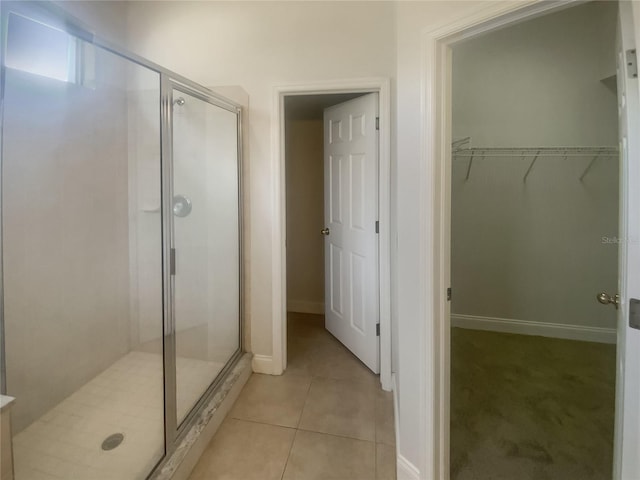 bathroom with tile patterned flooring and a shower with shower door