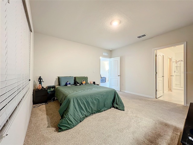 carpeted bedroom with connected bathroom and a textured ceiling