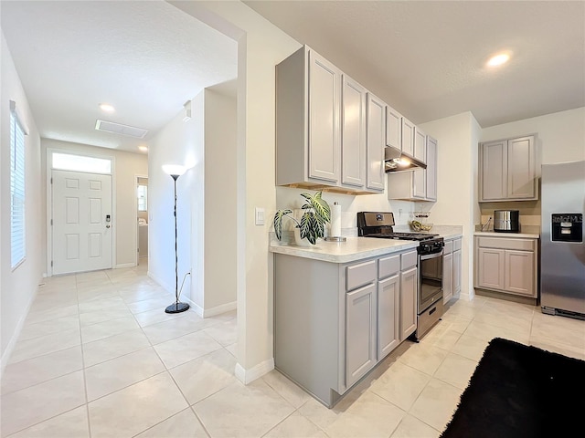 kitchen with gray cabinetry, light tile patterned flooring, and appliances with stainless steel finishes