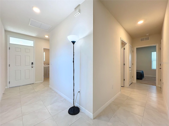 corridor featuring light tile patterned floors and washer / clothes dryer