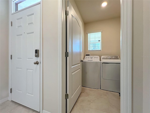 laundry room featuring washing machine and dryer and light tile patterned flooring