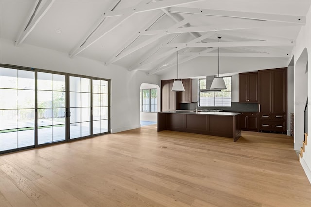 kitchen with pendant lighting, a kitchen island, light wood-type flooring, and beamed ceiling