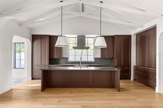 kitchen with light hardwood / wood-style flooring, lofted ceiling with beams, backsplash, island exhaust hood, and decorative light fixtures