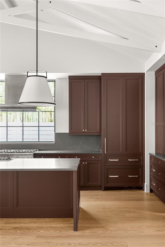 kitchen with backsplash, vaulted ceiling with beams, plenty of natural light, and light hardwood / wood-style floors