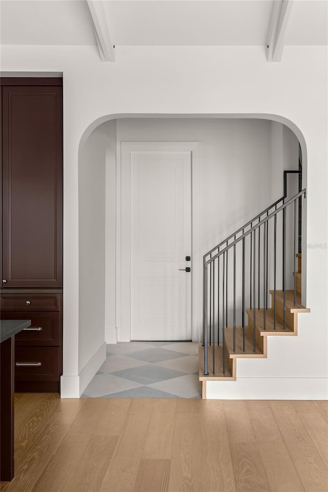 entryway with beam ceiling and wood-type flooring