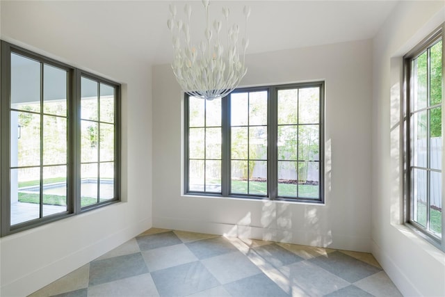 unfurnished room with an inviting chandelier