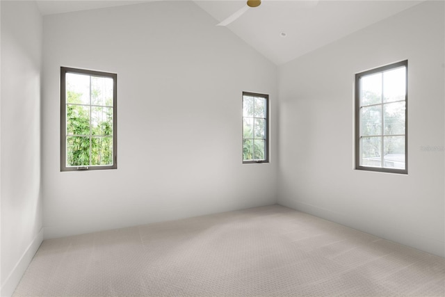 carpeted spare room featuring ceiling fan and vaulted ceiling