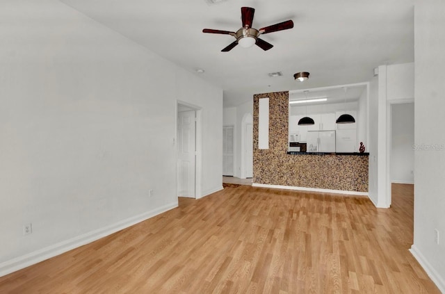 unfurnished living room featuring ceiling fan and light hardwood / wood-style flooring