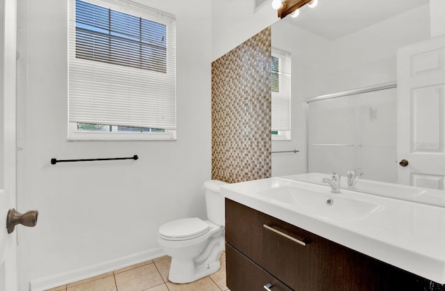 bathroom featuring tile patterned floors, vanity, toilet, and a shower with door