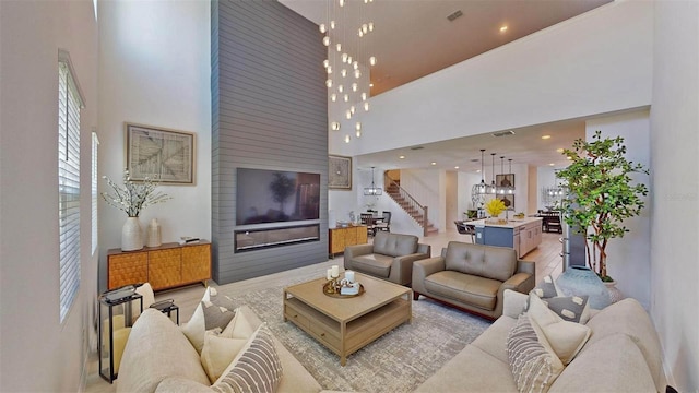 living room with light hardwood / wood-style floors and a towering ceiling