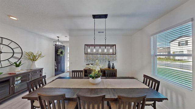 dining area with light hardwood / wood-style flooring and a textured ceiling