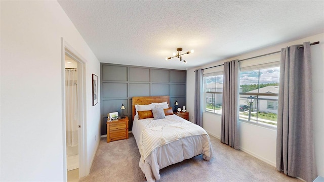 carpeted bedroom with a textured ceiling and a notable chandelier