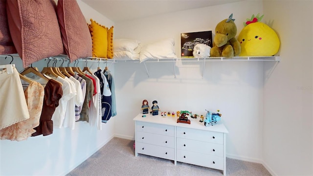 walk in closet featuring light colored carpet