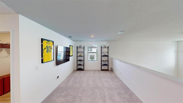 carpeted spare room featuring a textured ceiling