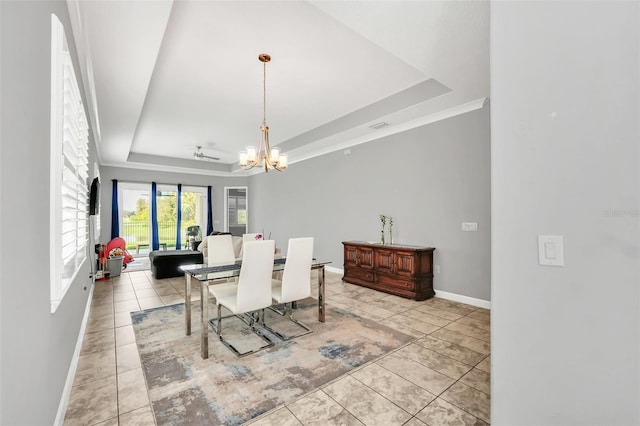 dining area featuring a tray ceiling, an inviting chandelier, and light tile patterned flooring