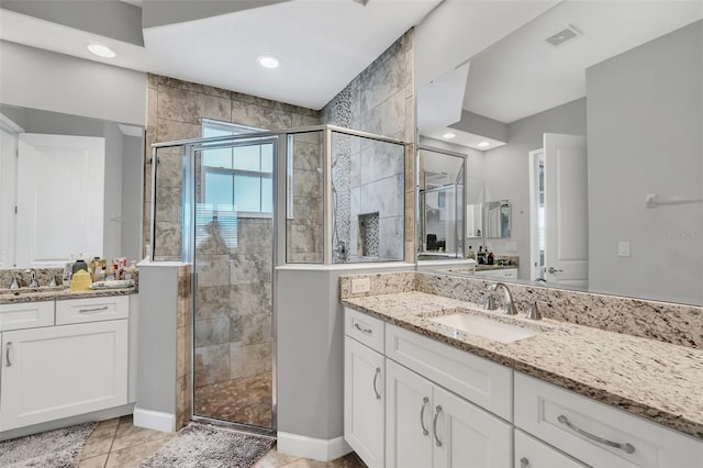 bathroom featuring vanity, tile patterned floors, and walk in shower