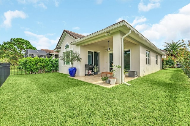 rear view of house with a yard, a patio, ceiling fan, and a lanai