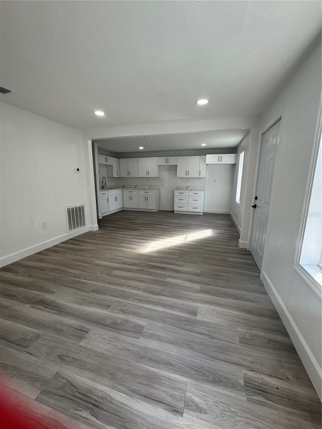 unfurnished living room featuring sink and dark hardwood / wood-style floors