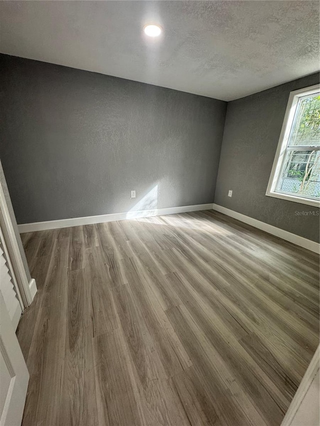 spare room with hardwood / wood-style flooring and a textured ceiling