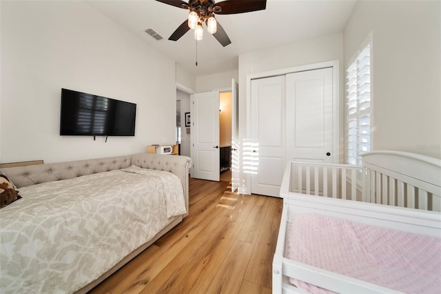 bedroom with light wood-type flooring, a closet, and ceiling fan