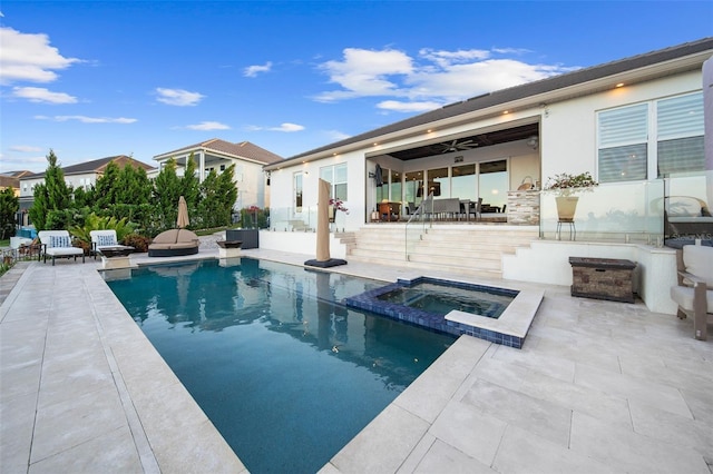 view of swimming pool featuring ceiling fan, a patio area, and an in ground hot tub