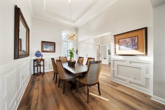 dining room featuring hardwood / wood-style flooring, an inviting chandelier, and ornamental molding