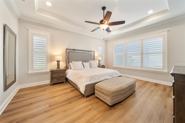 bedroom featuring a tray ceiling, ceiling fan, crown molding, and light wood-type flooring