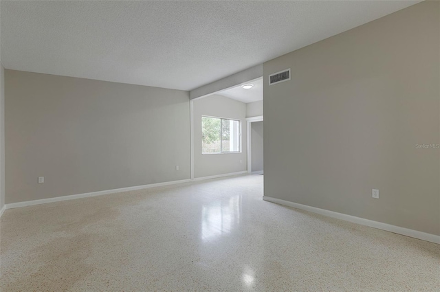 unfurnished room featuring a textured ceiling