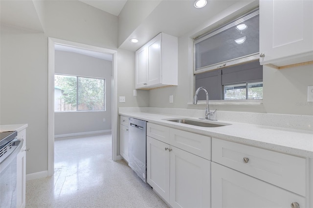 kitchen with light stone countertops, sink, white cabinetry, and stainless steel appliances