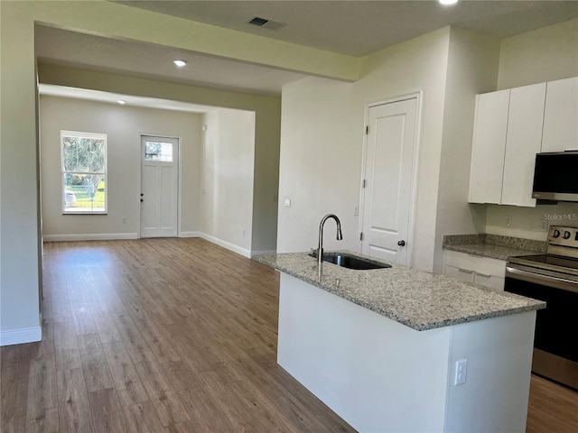 kitchen with stainless steel appliances, sink, a center island with sink, light hardwood / wood-style flooring, and white cabinetry