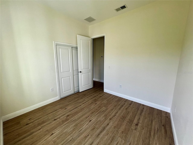 unfurnished room featuring dark wood-type flooring