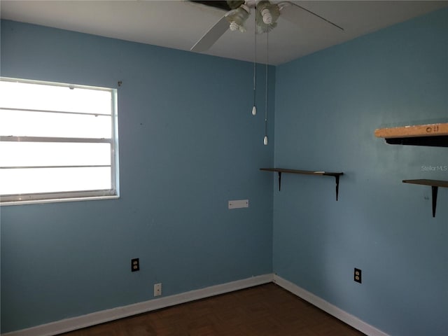 spare room with dark parquet floors and ceiling fan