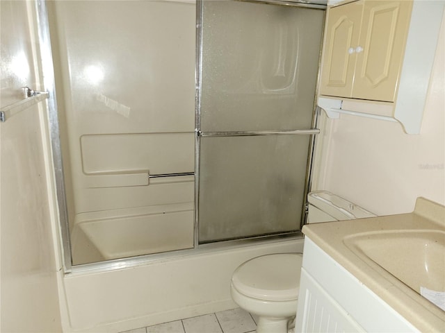 full bathroom featuring tile patterned floors, vanity, enclosed tub / shower combo, and toilet