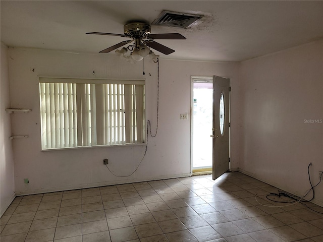 tiled empty room featuring ceiling fan