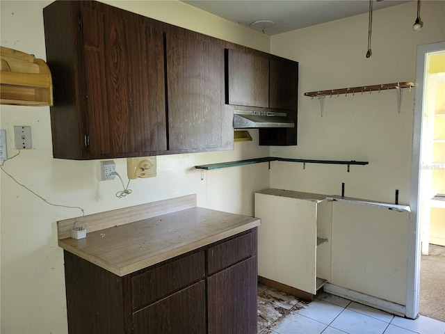 kitchen with dark brown cabinetry and light tile patterned flooring